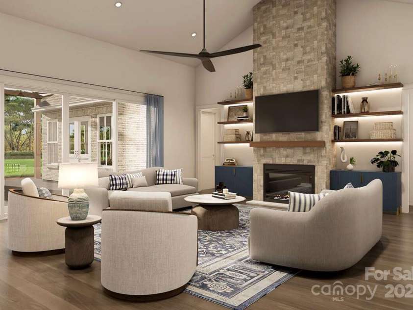 Lot 4 Country Estates Drive, Waxhaw, NC 28173.  MLS# CAR4278303, YatesRealty ID 1561. This inviting living room blends modern comfort with timeless elegance. A floor-to-ceiling stone fireplace anchors the space, flanked by built-in shelves with accent lighting and navy cabinetry for a pop of color.