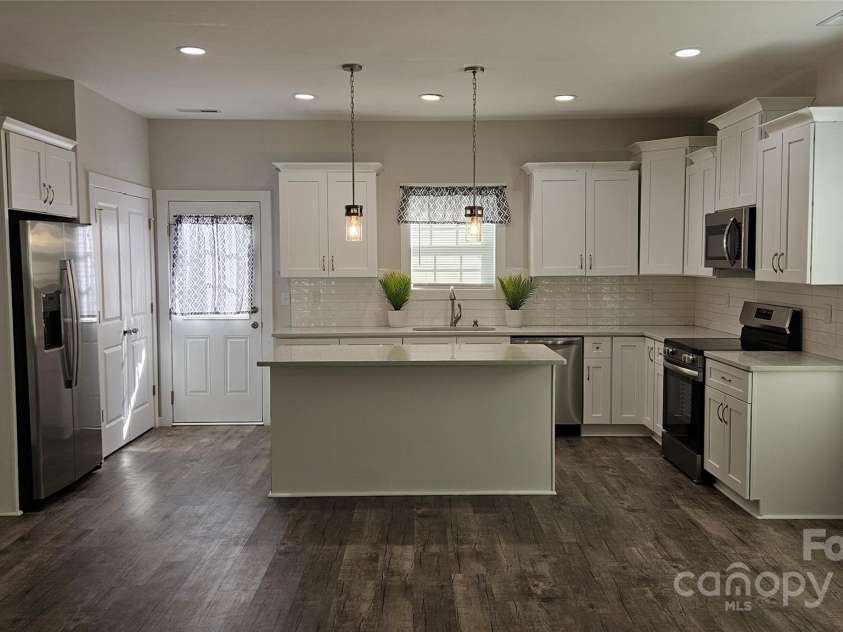 1124 Clouse Street, Gastonia, NC 28052.  MLS# CAR4239455, YatesRealty ID 15614. Modern white kitchen with quartz countertops, subway tile backsplash, self-closing cabinets and drawers, stainless steel appliances and large pantry