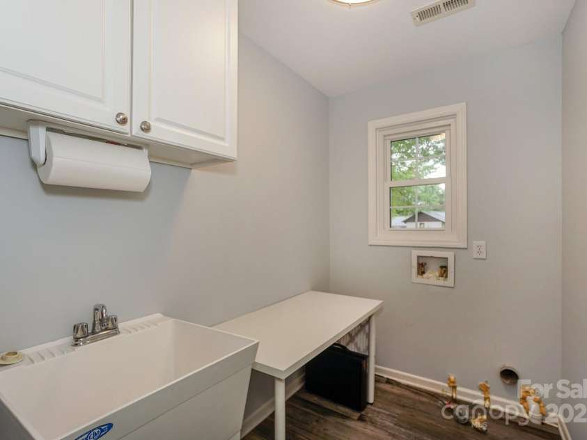 22025 Torrence Chapel Road, Cornelius, NC 28031.  MLS# CAR4244021, YatesRealty ID 15652. Laundry Room w/ Sink, Window, and cabinetry.