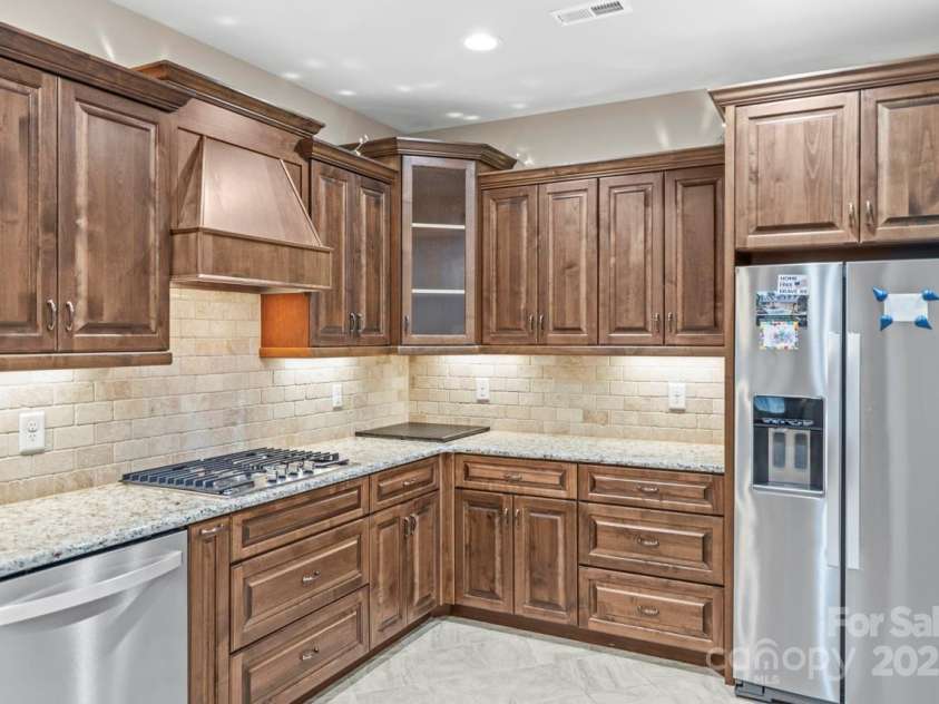 2008 Surefire Court, Denver, NC 28037.  MLS# CAR4220596, YatesRealty ID 15679. SS appliances including gas cooktop and refrigerator accentuate the granite counter tops and tile back splash