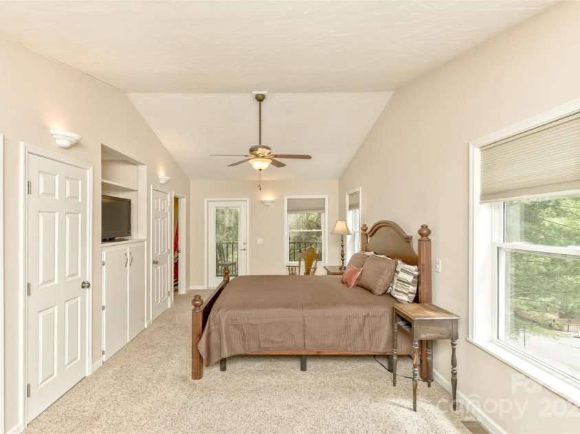 15 Beaverdam Knoll Road, Asheville, NC 28804.  MLS# CAR4283730, YatesRealty ID 1568. In addition to the two closets on each side of the built-in storage area, there is an additional large closet and small closet in the primary suite hallway. In the background is the private screened balcony and the 