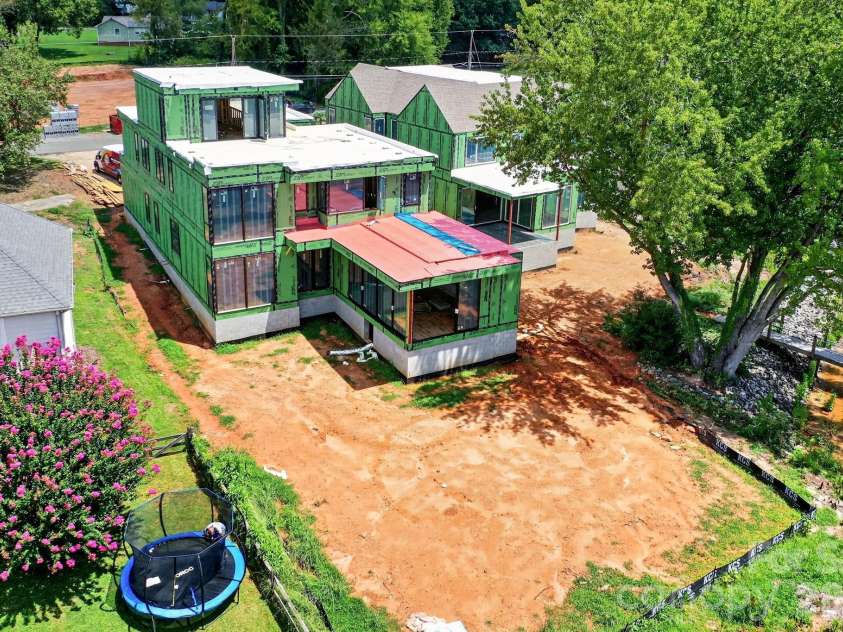 21506 Rio Oro Drive, Cornelius, NC 28031.  MLS# CAR4347482, YatesRealty ID 15702. Real life construction process showing the home is under roof with windows and roofing completed in 8/2026. Has a fantastic backyard for a pool!