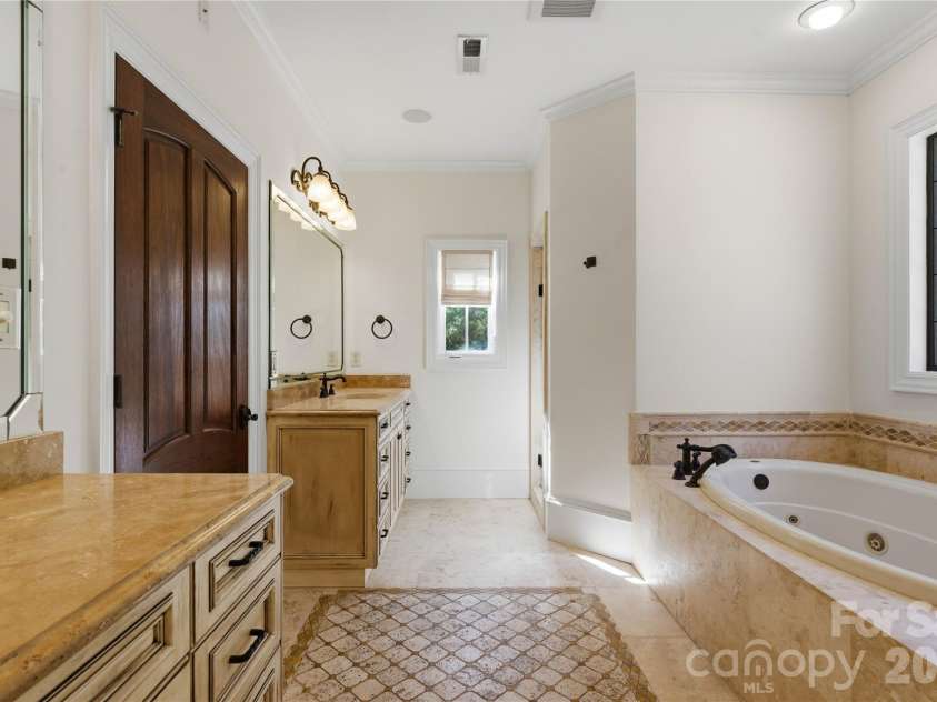 16849 Ashton Oaks Drive, Charlotte, NC 28278.  MLS# CAR4324899, YatesRealty ID 15742. Primary bath features all custom tile and stone work with split vanities and cloaked private room and walk in seamless shower.