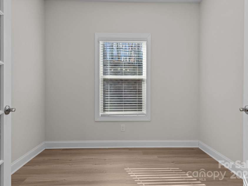 127 Tradesmen Trail, Troutman, NC 28166.  MLS# CAR4223474, YatesRealty ID 15779. At the back of the house, you'll find a peaceful office space with double doors featuring glass panels, allowing for natural light to fill the room. This versatile area is perfect for working from home, a study, or a qu