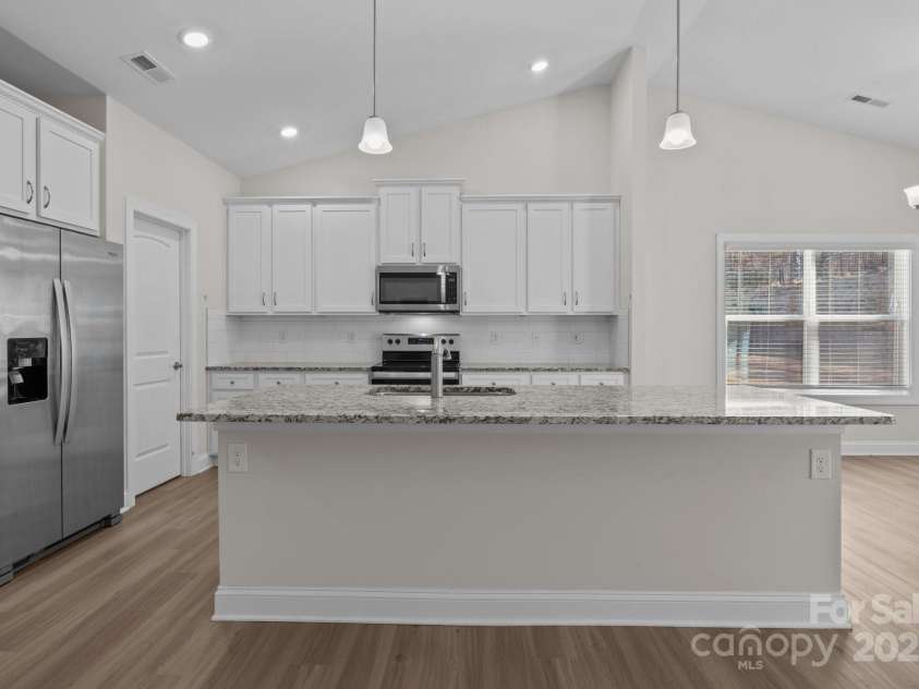 127 Tradesmen Trail, Troutman, NC 28166.  MLS# CAR4223474, YatesRealty ID 15779. KitchenThe modern kitchen boasts stainless steel appliances, ample cabinetry, and a large island with seating. Its functional layout is ideal for both everyday cooking and hosting gatherings.