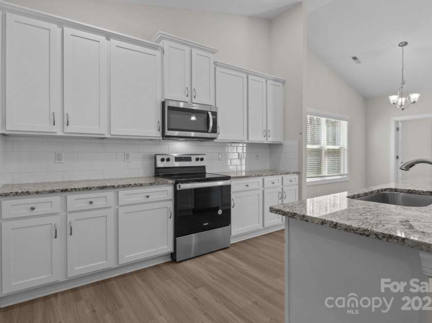 127 Tradesmen Trail, Troutman, NC 28166.  MLS# CAR4223474, YatesRealty ID 15779. KitchenThe modern kitchen boasts stainless steel appliances, ample cabinetry, and a large island with seating. Its functional layout is ideal for both everyday cooking and hosting gatherings.