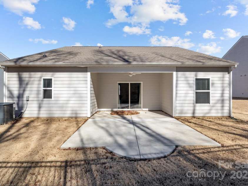 127 Tradesmen Trail, Troutman, NC 28166.  MLS# CAR4223474, YatesRealty ID 15779. The backyard offers a private outdoor space, perfect for relaxation or entertaining. The owner has extended the rear patio, providing even more room for outdoor living and dining. The well-maintained lawn offers ample s