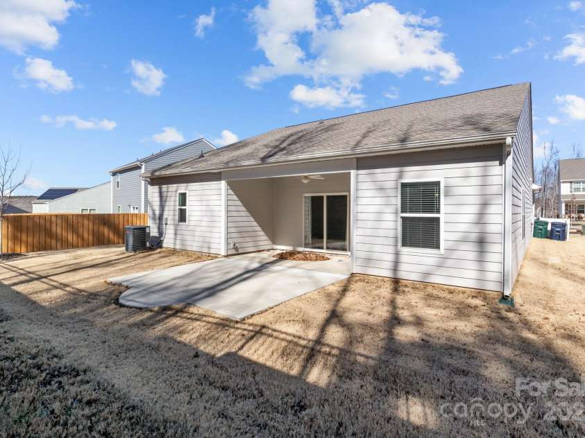 127 Tradesmen Trail, Troutman, NC 28166.  MLS# CAR4223474, YatesRealty ID 15779. The backyard offers a private outdoor space, perfect for relaxation or entertaining. The owner has extended the rear patio, providing even more room for outdoor living and dining. The well-maintained lawn offers ample s