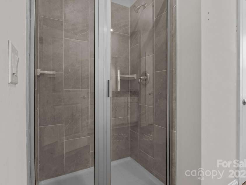 127 Tradesmen Trail, Troutman, NC 28166.  MLS# CAR4223474, YatesRealty ID 15779. The en-suite bathroom includes dual vanities, a large shower, and a linen closet for extra storage, all enhanced by natural light from a well-placed window, creating a bright and functional space.