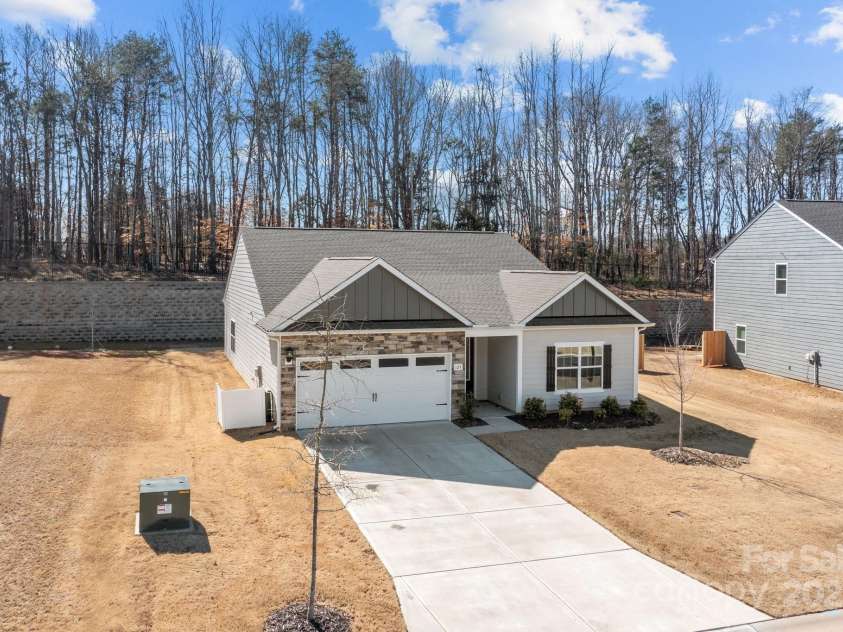 127 Tradesmen Trail, Troutman, NC 28166.  MLS# CAR4223474, YatesRealty ID 15779. The front of the home showcases the durable hardyboard siding and elegant stacked stone veneer, creating a timeless and stylish exterior. The two-car garage adds both convenience and functionality, while the overall des