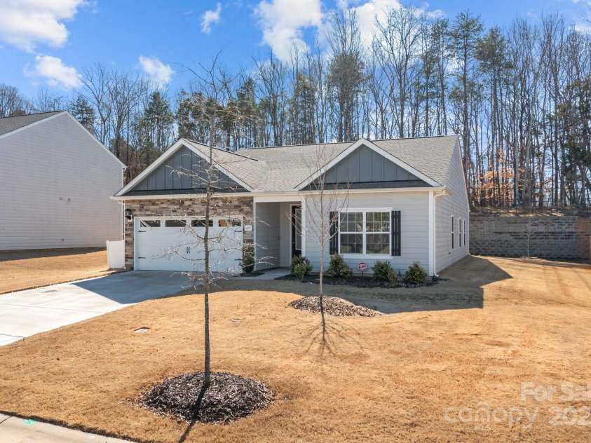 127 Tradesmen Trail, Troutman, NC 28166.  MLS# CAR4223474, YatesRealty ID 15779. The front of the home showcases the durable hardyboard siding and elegant stacked stone veneer, creating a timeless and stylish exterior. The two-car garage adds both convenience and functionality, while the overall des