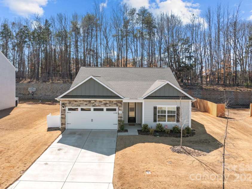 127 Tradesmen Trail, Troutman, NC 28166.  MLS# CAR4223474, YatesRealty ID 15779. The front of the home showcases the durable hardyboard siding and elegant stacked stone veneer, creating a timeless and stylish exterior. The two-car garage adds both convenience and functionality, while the overall des