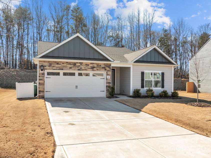 127 Tradesmen Trail, Troutman, NC 28166.  MLS# CAR4223474, YatesRealty ID 15779. The front of the home showcases the durable hardyboard siding and elegant stacked stone veneer, creating a timeless and stylish exterior. The two-car garage adds both convenience and functionality, while the overall des