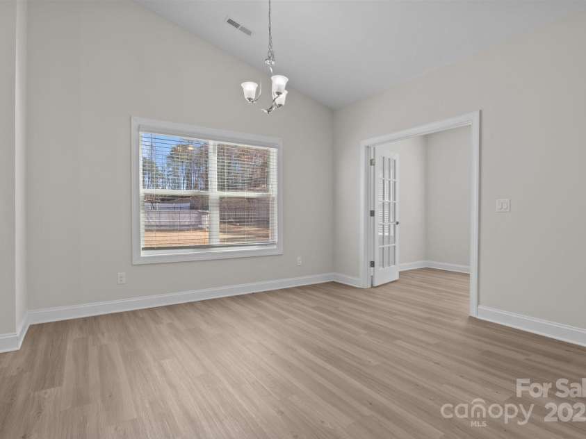 127 Tradesmen Trail, Troutman, NC 28166.  MLS# CAR4223474, YatesRealty ID 15779. The spacious dining area is open to both the kitchen and the great room, creating a seamless flow throughout the main living space. Natural light pours in, highlighting the inviting atmosphere and making it the perfect 