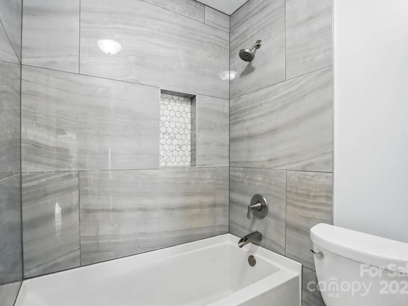 8833 Cavonnier Lane, Charlotte, NC 28216.  MLS# CAR4254092, YatesRealty ID 15858. Hallway bathroom, modern tub and tile shower