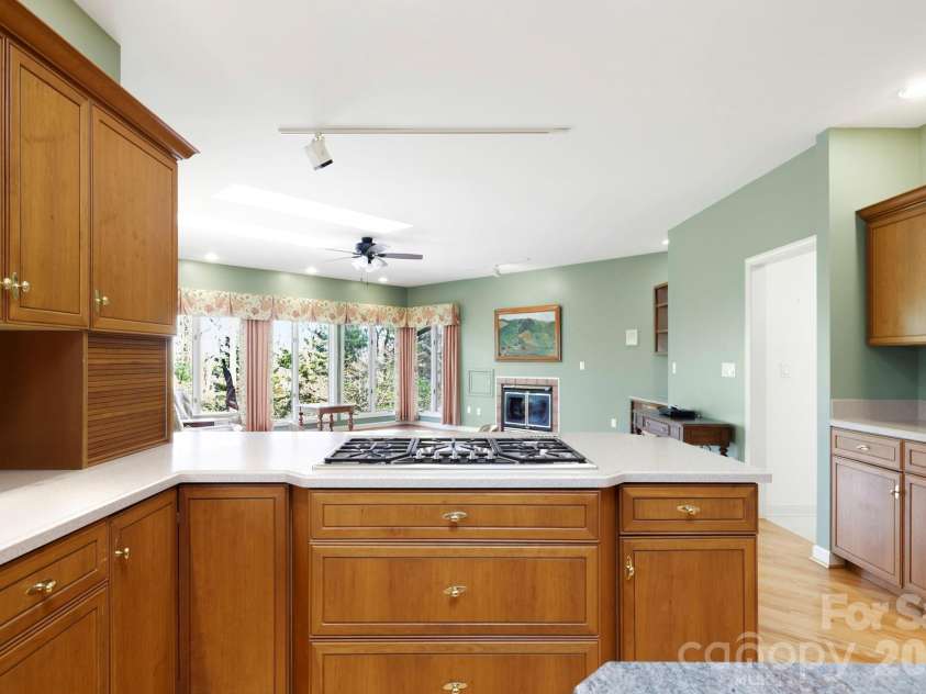 100 Elmridge Drive, Flat Rock, NC 28731.  MLS# CAR4366738, YatesRealty ID 15859. Kitchen opens to cozy den with fireplace