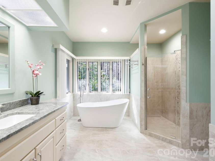 100 Elmridge Drive, Flat Rock, NC 28731.  MLS# CAR4366738, YatesRealty ID 15859. Updated primary bath with soaking tub and walk-in tile shower