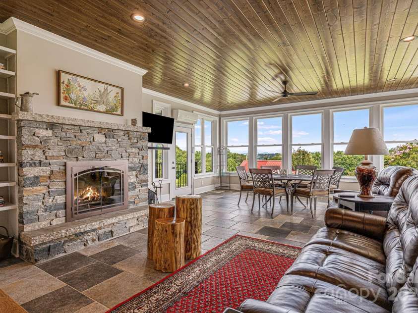 360 Turkey Branch Road, Mars Hill, NC 28754.  MLS# CAR4218460, YatesRealty ID 1586. Sunroom seating with wood burning fireplace.