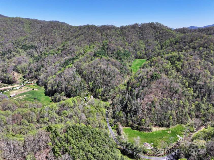 2180 Pigeon Roost Road, Green Mountain, NC 28740.  MLS# CAR4137054, YatesRealty ID 1587. Aerial of two lower pastures and the upper hidden meadow