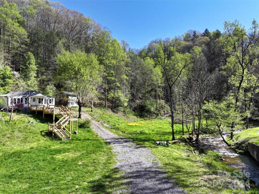 2180 Pigeon Roost Road, Green Mountain, NC 28740.  MLS# CAR4137054, YatesRealty ID 1587. Farmhouse with new deck overlooking Pigeon Roost Creek