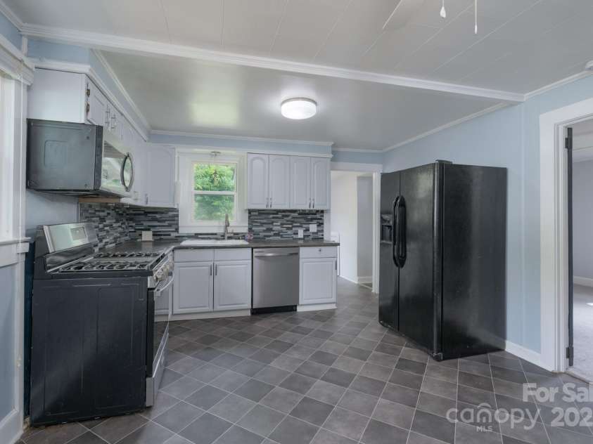 917 Laye Street, Belmont, NC 28012.  MLS# CAR4254861, YatesRealty ID 15892. Nicely appointed kitchen, freshly painted cabinets - nearly new gas stove with new microwave and new dishwasher in stainles steel and black. Tiled backsplash and concrete countertops