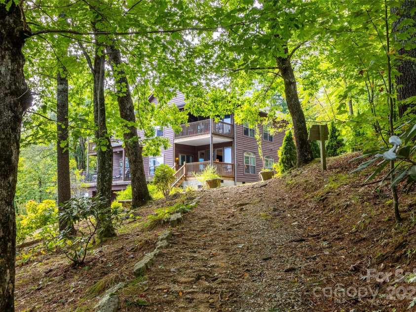 30 Lower Tanglewood Road, Lake Toxaway, NC 28747.  MLS# CAR4176732, YatesRealty ID 15904. Walking path down to waterfall from the condo