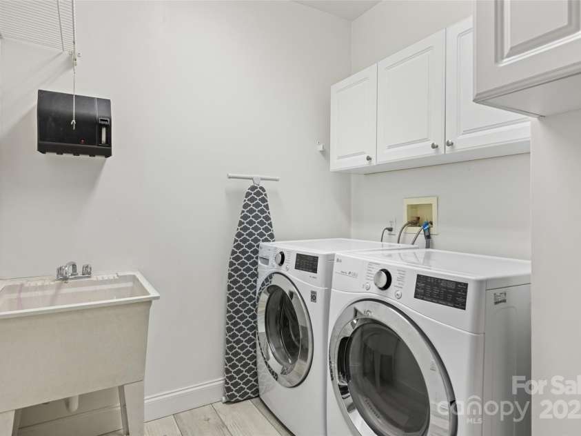 149 Southbrook Lane, Fletcher, NC 28732.  MLS# CAR4221393, YatesRealty ID 15918. An oversized laundry room with plenty of storage and a sink.
