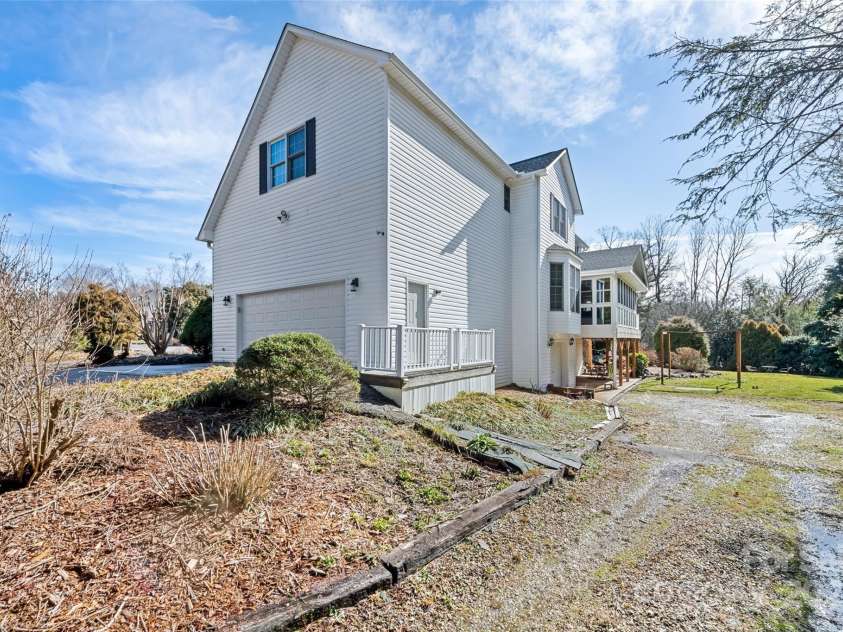149 Southbrook Lane, Fletcher, NC 28732.  MLS# CAR4221393, YatesRealty ID 15918. From the main driveway is a gravel driveway leading to a one car garage on the basement level with ample storage.