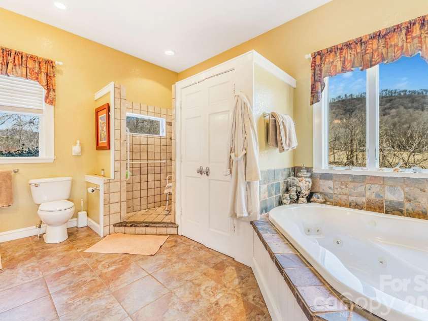 22 Mountain Spring Lane, Canton, NC 28716.  MLS# CAR4346093, YatesRealty ID 15957. Large primary en suite with garden tub and tiled shower