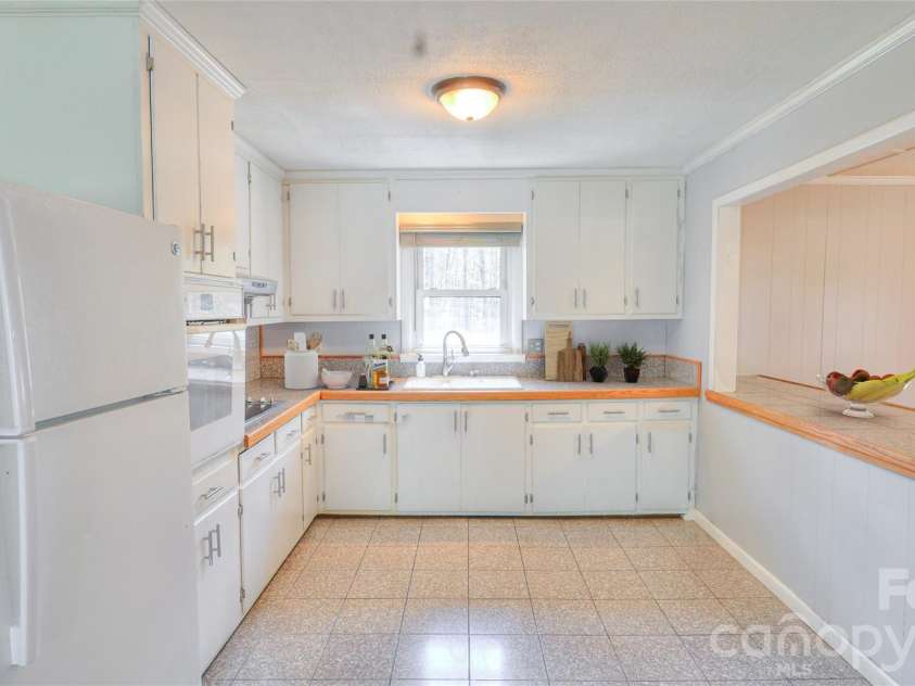 1130 Allman Extension, Mount Pleasant, NC 28124.  MLS# CAR4365087, YatesRealty ID 15982. Bright and functional kitchen featuring ample cabinetry, granite-look countertops, and a spacious breakfast bar—perfect for casual dining and entertaining.