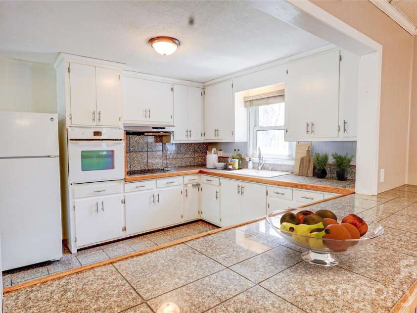 1130 Allman Extension, Mount Pleasant, NC 28124.  MLS# CAR4365087, YatesRealty ID 15982. Bright and functional kitchen featuring ample cabinetry, granite-look countertops, and a spacious breakfast bar—perfect for casual dining and entertaining.