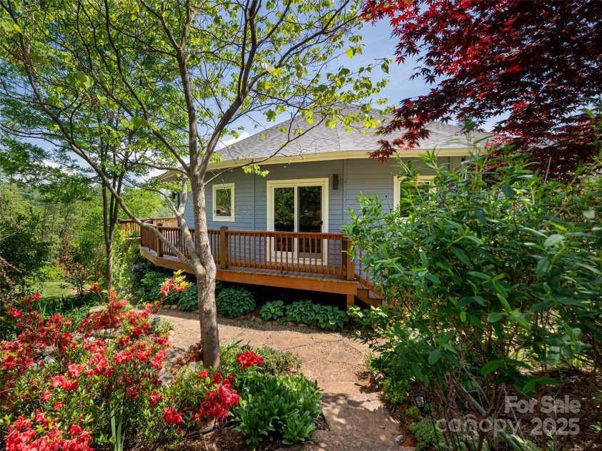 15 Sassy Lane, Asheville, NC 28805.  MLS# CAR4248835, YatesRealty ID 16032. A gardener's paradise surrounded by flowering trees, fruit trees, raised beds for vegetable and flower gardens, cascading water features, and walking trail surround the house
