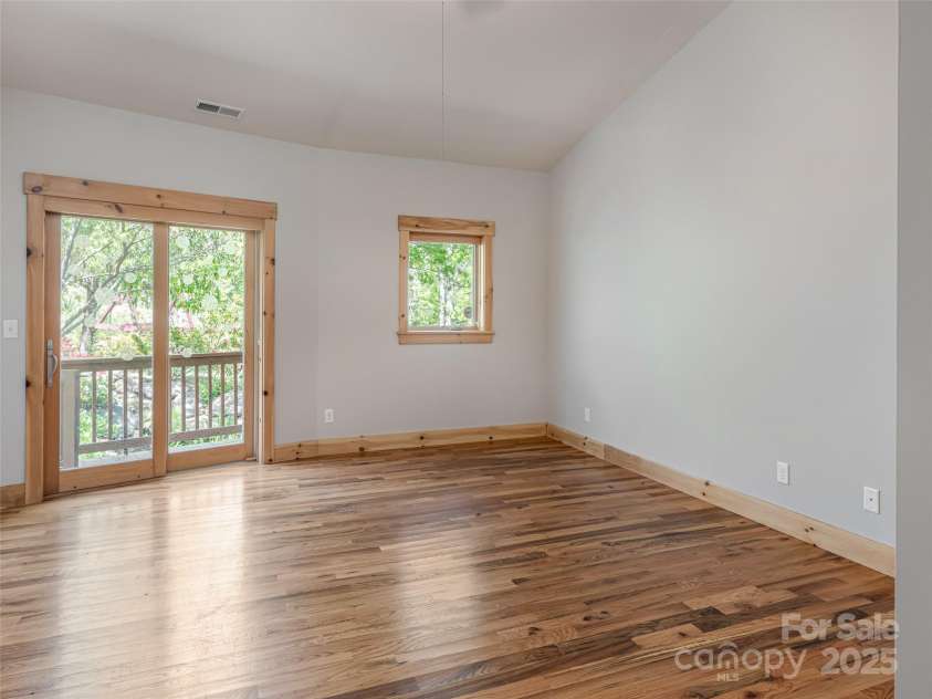15 Sassy Lane, Asheville, NC 28805.  MLS# CAR4248835, YatesRealty ID 16032. Primary Bedroom with sliding doors to wrap around deck and gardens