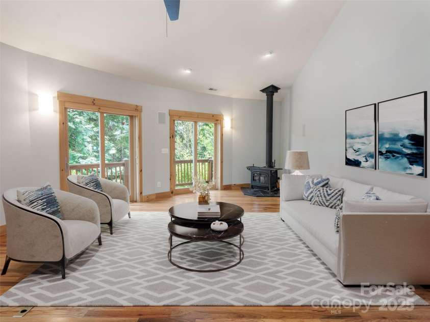 15 Sassy Lane, Asheville, NC 28805.  MLS# CAR4248835, YatesRealty ID 16032. Virtual staging of large Great Room with sliding doors to wrap-around deck, wood burning fireplace, domed ceiling with skylight create natural light-filled room