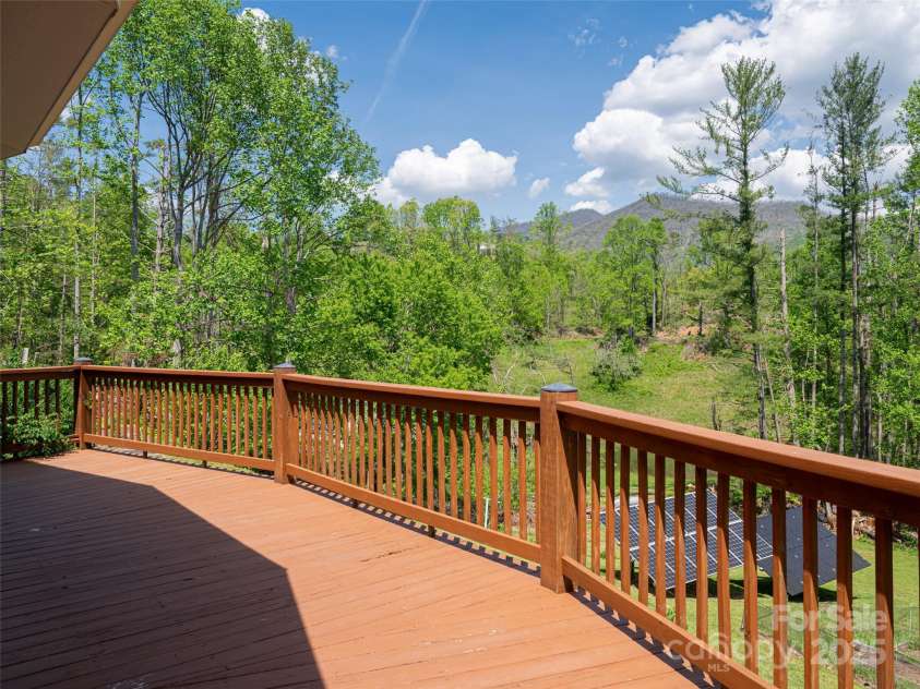 15 Sassy Lane, Asheville, NC 28805.  MLS# CAR4248835, YatesRealty ID 16032. Wrap around wooden deck overlooking the gardens with long range mountain views. Solar panels provide for an energy efficient home