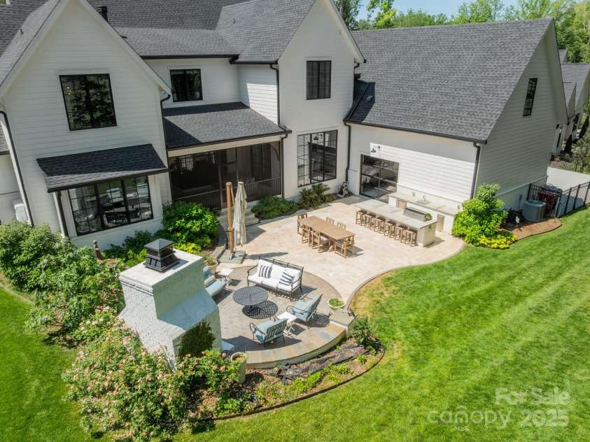 14228 Ryker Way, Davidson, NC 28036.  MLS# CAR4319295, YatesRealty ID 16043. Expansive travertine patio with full outdoor kitchen, and thoughtfully added glass door for easy access to yard tools and outdoor activities equipment.