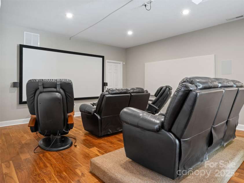 737 Streamside Drive, Arden, NC 28704.  MLS# CAR4248718, YatesRealty ID 16049. On the lower level the largest room has been outfitted as a theater room. All of the equipment conveys as well as one of the massage chairs and the plush sofas