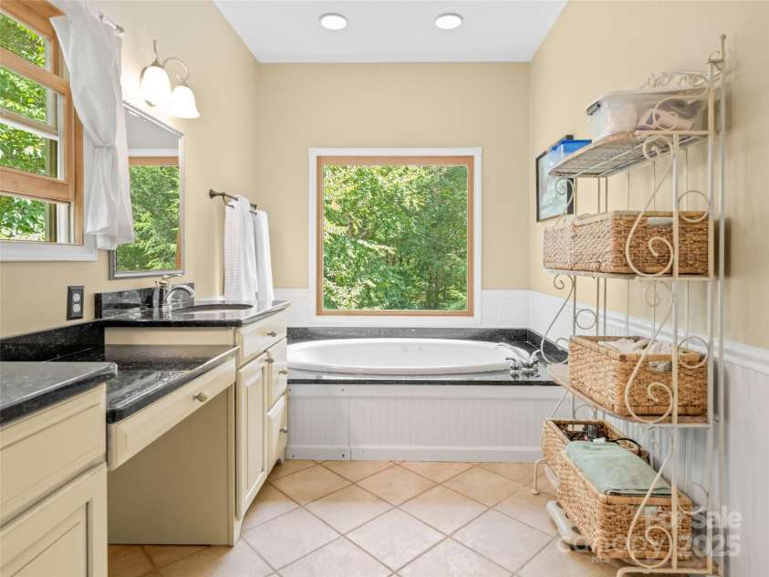 737 Streamside Drive, Arden, NC 28704.  MLS# CAR4248718, YatesRealty ID 16049. The primary bath with the garden tub overlooking the very private back yard