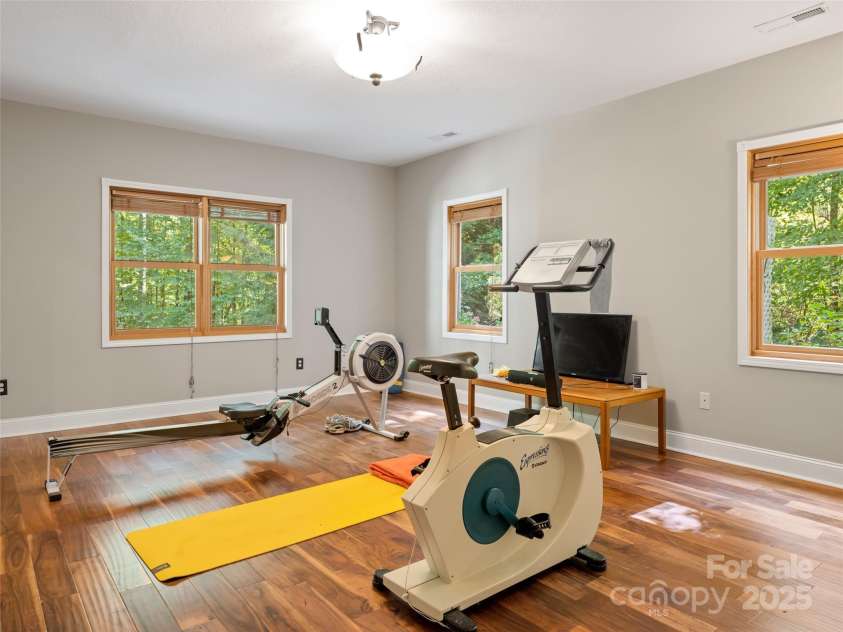 737 Streamside Drive, Arden, NC 28704.  MLS# CAR4248718, YatesRealty ID 16049. This 250+SF room on the lower level has a closet and accommodates multitude uses .Here it is used as a exercise room.