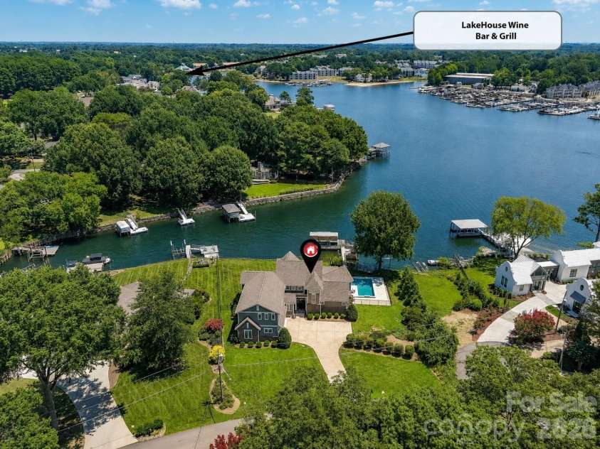 18014 Whispering Oaks Drive, Cornelius, NC 28031.  MLS# CAR4356897, YatesRealty ID 16097. Aerial view highlights the home's exceptional waterfront setting with quick access to open water and nearby LakeHouse Wine Bar & Grill. (Virtually enhanced lake levels)