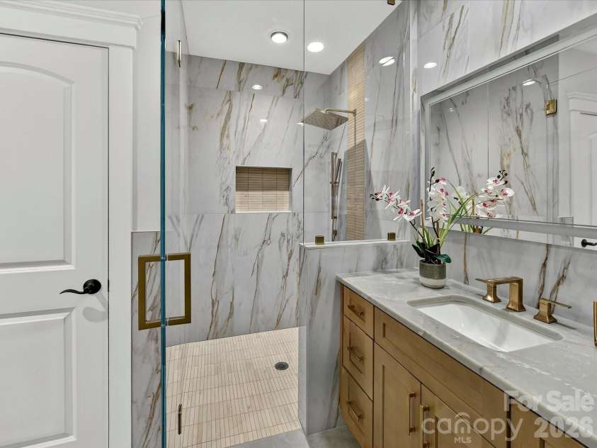 18014 Whispering Oaks Drive, Cornelius, NC 28031.  MLS# CAR4356897, YatesRealty ID 16097. Bedroom 4 features a beautifully appointed private ensuite bath with a custom tiled walk-in shower, quartz vanity, designer finishes, and upscale fixtures.