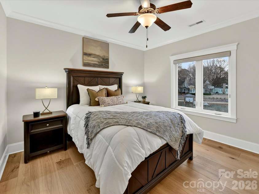 18014 Whispering Oaks Drive, Cornelius, NC 28031.  MLS# CAR4356897, YatesRealty ID 16097. Bedroom 4 offers a spacious layout with abundant natural light, ceiling fan, and peaceful water views for a comfortable guest or family retreat.