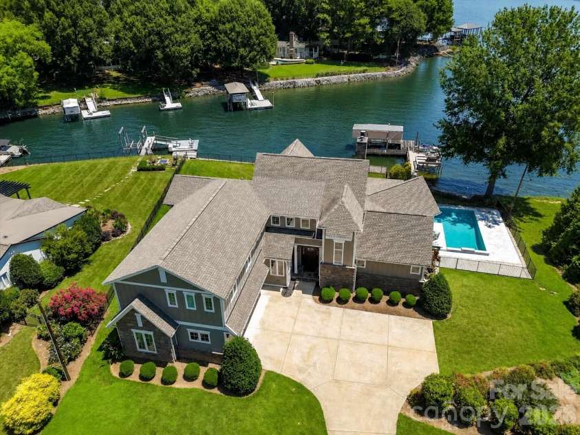 18014 Whispering Oaks Drive, Cornelius, NC 28031.  MLS# CAR4356897, YatesRealty ID 16097. Elegant waterfront home with a private pool, dock, and breathtaking lake views, offering an exceptional blend of luxury, privacy, and Lake Norman living. (Virtually enhanced lake levels)