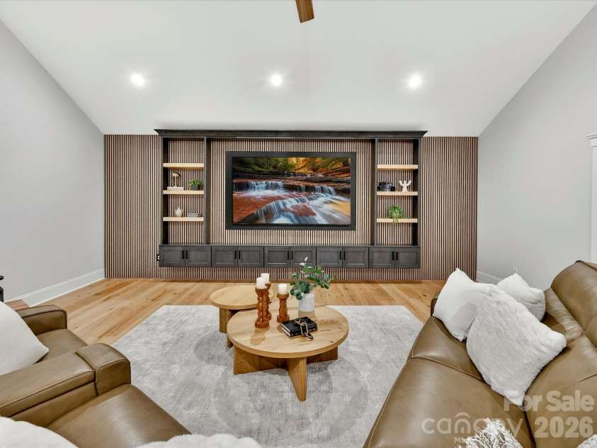 18014 Whispering Oaks Drive, Cornelius, NC 28031.  MLS# CAR4356897, YatesRealty ID 16097. Expansive bonus room showcases a custom built-in media wall, vaulted ceiling, and flexible space ideal for movie nights, gaming, or gathering with family and friends.