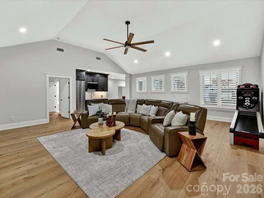 18014 Whispering Oaks Drive, Cornelius, NC 28031.  MLS# CAR4356897, YatesRealty ID 16097. Expansive bonus room showcases a custom built-in media wall, vaulted ceiling, and flexible space ideal for movie nights, gaming, or gathering with family and friends.