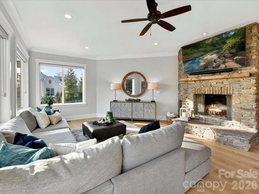 18014 Whispering Oaks Drive, Cornelius, NC 28031.  MLS# CAR4356897, YatesRealty ID 16097. Inviting Great Room showcases a striking floor-to-ceiling stone fireplace, expansive windows with stunning Lake Norman views, and seamless access to the outdoor living spaces.