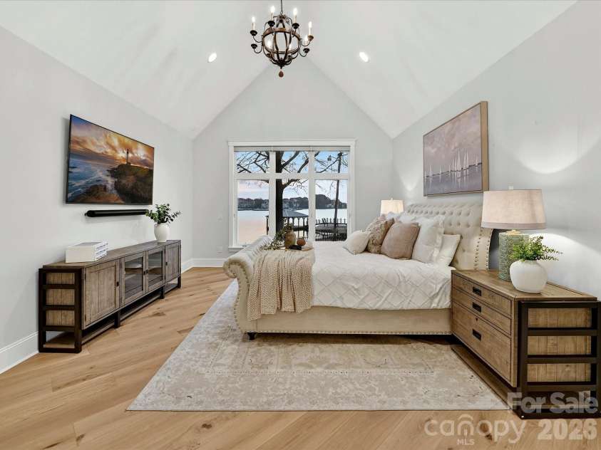 18014 Whispering Oaks Drive, Cornelius, NC 28031.  MLS# CAR4356897, YatesRealty ID 16097. Luxurious main-level primary suite features a soaring vaulted ceiling, expansive Lake Norman views, and a peaceful retreat designed for comfort and relaxation.