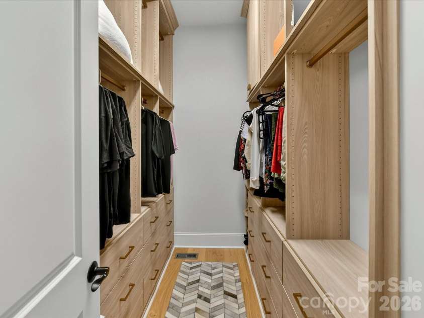 18014 Whispering Oaks Drive, Cornelius, NC 28031.  MLS# CAR4356897, YatesRealty ID 16097. Spacious custom walk-in primary closet features built-in shelving, abundant hanging space, and extensive drawer storage for exceptional organization.