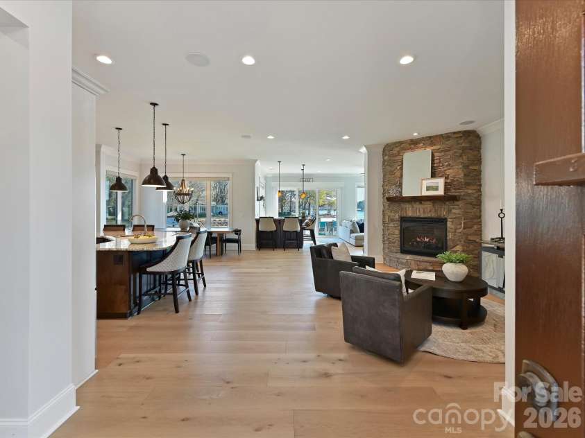 18014 Whispering Oaks Drive, Cornelius, NC 28031.  MLS# CAR4356897, YatesRealty ID 16097. Step into a light-filled, open-concept living space where the gourmet kitchen, impressive stone fireplace, and expansive lake views create an unforgettable first impression.