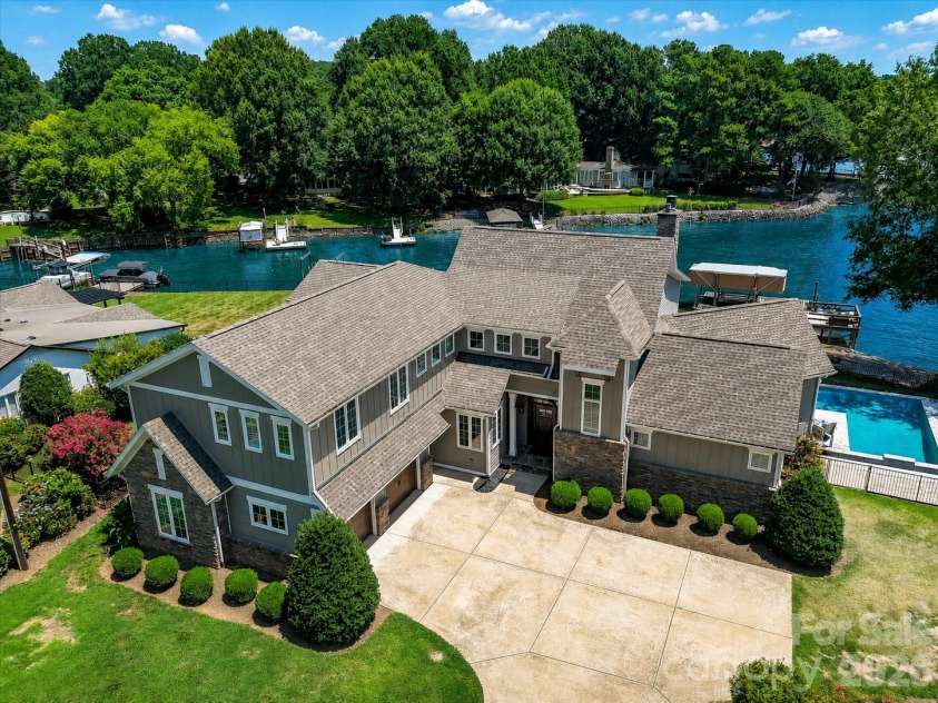 18014 Whispering Oaks Drive, Cornelius, NC 28031.  MLS# CAR4356897, YatesRealty ID 16097. Stunning waterfront retreat showcasing breathtaking lake views, a sparkling pool, private dock, and beautifully landscaped grounds—offering the ultimate Lake Norman lifestyle. (Virtually enhanced lake levels)